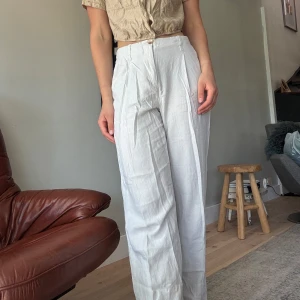 Beige linnebyxor med hög midja -  Beige/benvita linnebyxor med hög midja och vida ben. Byxorna har hällor för bälte och stängs med knapp och dragkedja. Är i behov av att strykas, men annars i fint skick! Fler bilder finns att få. (Funkar bra med beige/ljusa underkläder utan att det syns igenom)