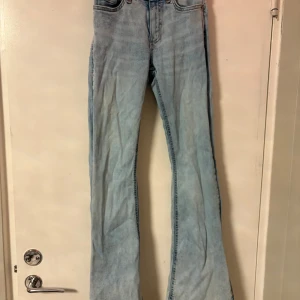 Ljusblå bootcut jeans från Gina Tricot - Säljer ett par ljusblå bootcut jeans från Gina Tricot, modell Perfect Jeans. De har klassisk femficksdesign, hög midja och är tillverkade i mjukt jeanstyg. Snyggt utsvängda ben och ljus tvätt ger en fräsch vibe till din outfit.