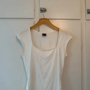 Vit topp ginatricot  - Enkel och fräsch vit linnetopp från Gina Tricot med rundad, något djupare halsringning. Toppen är ärmlös och har en rak, klassisk passform som funkar till allt. Passar xs-m