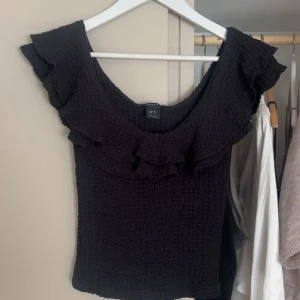 Svart volangtopp från Lindex - Säljer en jättefin topp från Lindex. Har aldrig andvänt den så den är som ny. Storlek Xs. Nypris - 299 💕