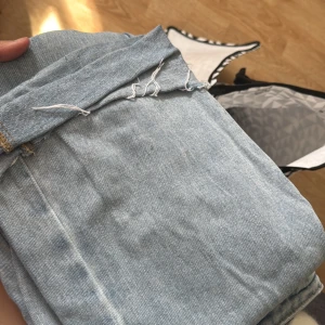 Ljusblå raka jeans med rå kant - Säljer ett par ljusblå jeans med klassisk femficksdesign och rå, fransig kant nedtill. Jeansen har en rak passform och är tillverkade i denim av bomull. Perfekta för en avslappnad och trendig look.