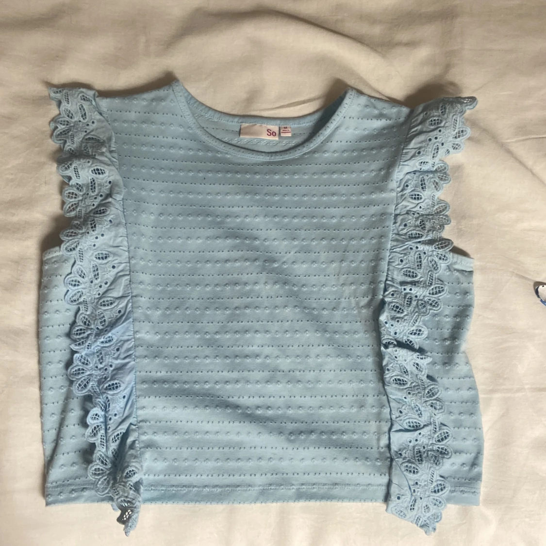 Ljusblå topp med spetsvolang