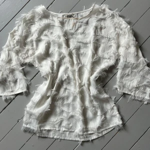 Vit fransig blus från Twist & Tango - Vit blus med fransar/ fjädrar. 