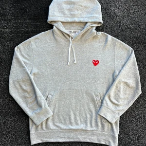 CDG Hoodie - Snygg grå hoodie från Comme des Garçons Play med klassiskt rött hjärta på bröstet. Skick 9/10, Storlek L men passar M/L. Pris går att diskutera✅