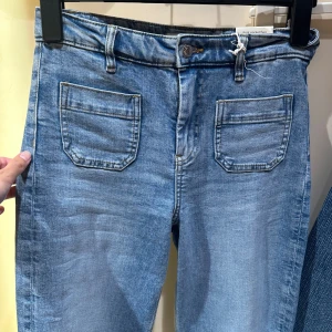 Ljusblå wide jeans med framfickor - Högmidjade, ljusblå jeans från Gina Tricot. Endast använda en gång, köpte fel storlek. 