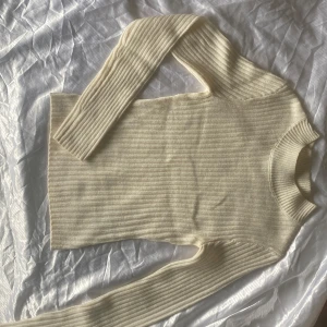 Ribbad vit stickad tröja H&M XS - Ribbad, vit stickad tröja från H&M i storlek XS. Tröjan har lång ärm, rund halsringning och är figurnära i modellen. Perfekt att styla med jeans eller kjol för en clean look.