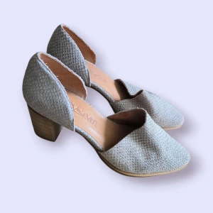 Pumps med blockklack från Sixtyseven - Snygga pumps från Sixtyseven i beige mocka med textur som påminner om ormskinn. Skorna har en stabil blockklack i trälook och rund tå. Perfekta för dig som vill ha en stilren men unik sko med lite edge. De är bekväma.