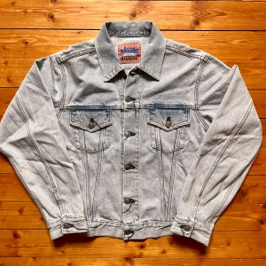 Ljusblå jeansjacka från Acne Studios - Säljer en klassisk ljusblå jeansjacka från Acne Studios. Jackan har raka linjer, två bröstfickor med lock och knappar, samt justerbara knappar vid ärmslut och midja. Perfekt oversized fit och tillverkad i robust denim. Snygg detalj med Acne Studios-märke på insidan.