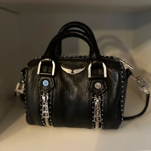 Zadig & Voltaire väska 🖤🖤 - Säljer min svarta handväska från Zadig & Voltaire i skinn med silverfärgade metalldetaljer, dubbla handtag och avtagbar axelrem. Den är köpt cirka två år sedan på deras hemsida och är i väldigt bra skick då jag inte har använt väskan så mycket!💕nypris: ca 3800kr❗️dustbag kommer med!!