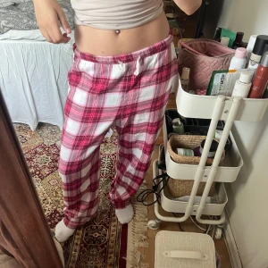 Rosa-rutiga mjukisbyxor från Lindex  - Supermysiga mjukisbyxor i rosa, rött och vitt rutigt mönster. Byxorna har resår i midjan med vit snörning och är tillverkade i mjukt bomullstyg. Säljer då jag har alldeles för mycket mjukis hemma! Storlek XS på dessa men passar även S beroende på hur man vill att dom ska sitta! Jag har S som referens 