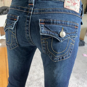 True Religion blå bootcut jeans - Jag säljer mina snygga True Religion jeans som jag tyvärr inte använder. Dom är mörkblåa och är i storlek W26. Dom är lågmidjade och är ÄNDAST använda 2 gånger💗