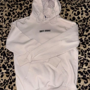 Ljus rosa hoodie med tryck - Säljer en ljus rosa hoodie med tryck på ryggen. Den är storlek xs men passar även s. Någon liten fläck på mudden på armen har den men inget man tänker på eller märker