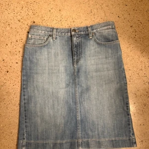 Jeanskjol från GANT - Snygg jeanskjol från GANT i klassisk blå denim. Kjolen har en rak passform med femficksdesign och bälteshällor. Perfekt för en avslappnad stil. 