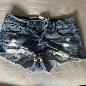 Blå jeansshorts från Hollister - Säljer ett par snygga blå jeansshorts från Hollister med låg midja. Storlek w25 eller XS.