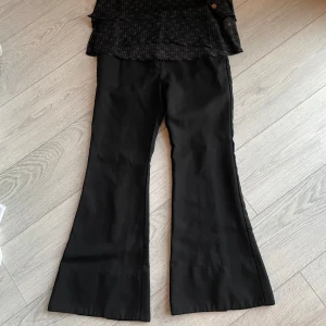 Svart ärmlös topp med mönster och svart byxor - Använd bara 1 gång. Byxor stl 34 och topp stl 164