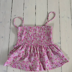 Blommig rosa linnetopp - Jättegulligt linne som man kan ta bort axelbanden på och göra till en kjol. Perfekt nu till sommaren ☀️💐💐