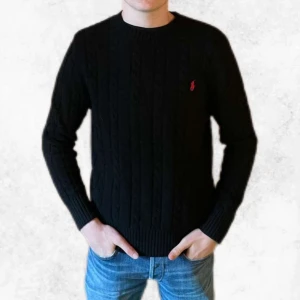 Svart kabelstickad tröja från Polo Ralph Lauren - Säljer en stilren svart stickad tröja från Polo Ralph Lauren med kabelstickat mönster och röd broderad logga på bröstet. Tröjan är i nyskick, har endast testas. Vid några frågor eller fler bilder så är det bara att höra av sig.