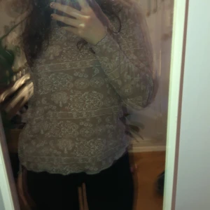 Beige långärmad tröja från Morrison - Säljer en beige långärmad tröja från Morrison med ett vackert vitt mönster. Tröjan har en normal passform och är perfekt för både vardag och speciella tillfällen. Den är tillverkad i ett mjukt material som känns skönt mot huden.