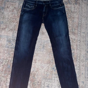 Mörkblå jeans från Replay - Snygga mörkblå jeans från Replay med klassisk femficksdesign och kontrastsömmar. De har en normal passform och är perfekta för en avslappnad stil. Märkeslogga på baksidan av midjan ger en extra touch.