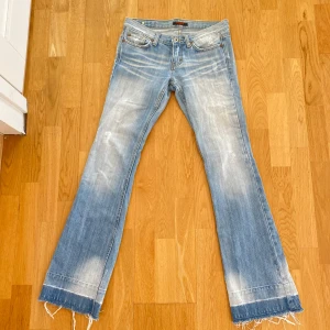 Blå bootcut jeans från Goza 💞 - Snygga blå bootcut jeans från Goza med slitna detaljer och fransar vid bensluten. Jeansen har en klassisk femficksdesign och är perfekta för en avslappnad stil. De har en ljus tvätt och är tillverkade i denim.  - midjemått är 73 cm runt 💞💞  