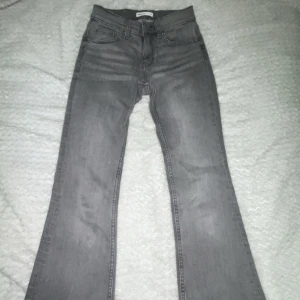 Grå jeans från Gina Tricot - Snygga grå jeans från Gina Tricot med en klassisk femficksdesign. De har en bootcut-stil som ger en trendig look. Perfekta för att matcha med både sneakers och klackar.