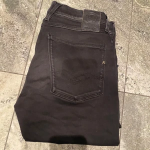 Svarta jeansbyxor från Replay - Snygga svarta jeansbyxor från Replay, modell Anbass.  Ny pris 1699 kr men jag säljer för endast 349kr.  Storlek 31/32.