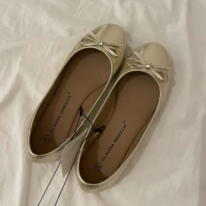 ballerina skor  - Guldiga ballerina skor, i nyskick, med lapp kvar ! 