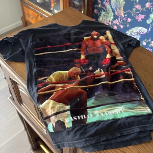 Svart t-shirt med boxningsmotiv från Bastille Rive Droite - Cool svart t-shirt från Bastille Rive Droite med ett stort boxningsmotiv på framsidan. Perfekt för dig som gillar unika tryck och sportig stil. T-shirten har korta ärmar och en normal passform. Ett måste för garderoben!