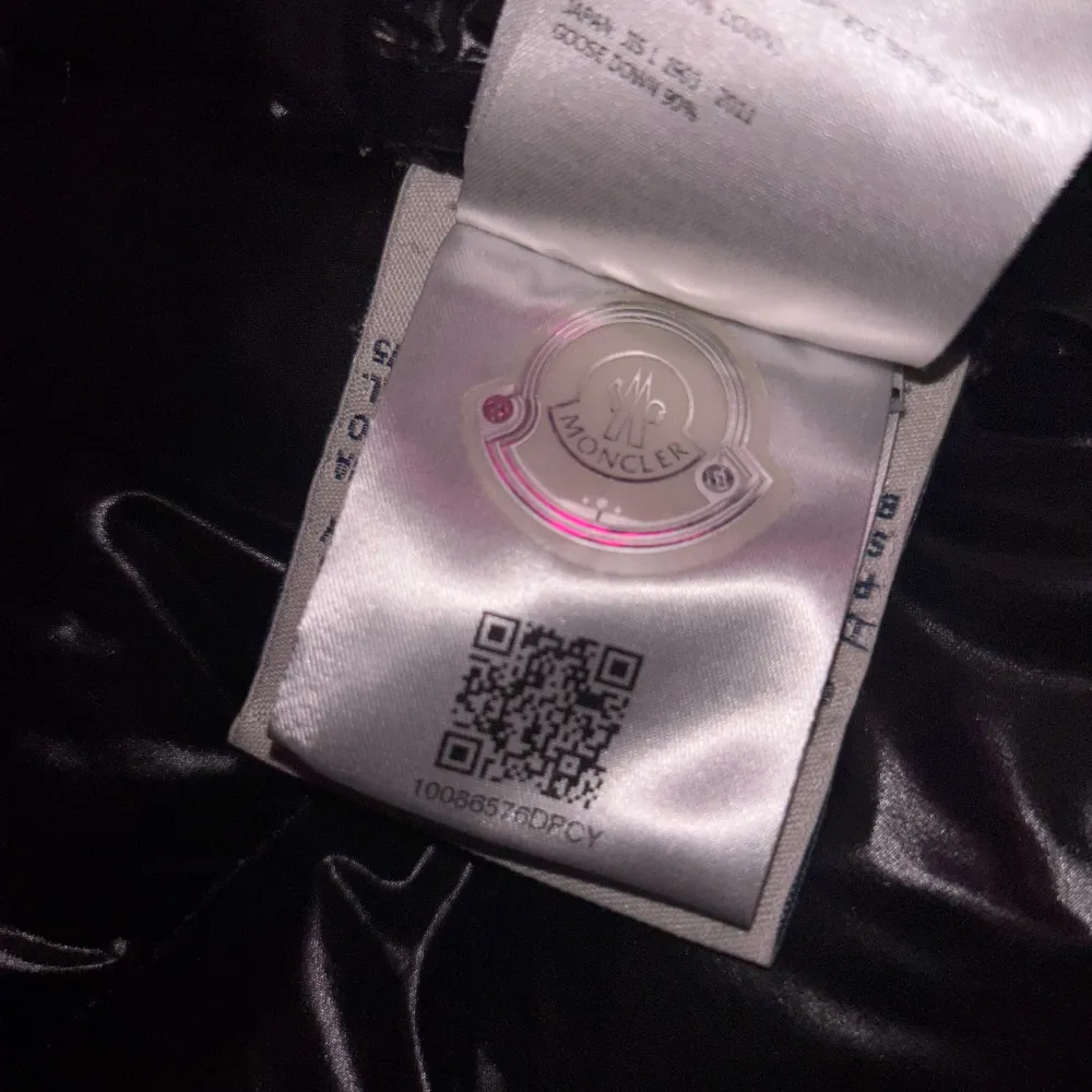 Säljer en snygg svart dunjacka från Moncler. Jackan har en glansig finish och är försedd med en dragkedja framtill. Den har långa ärmar och en praktisk ficka med Moncler-logga på ärmen. Perfekt för kyligare dagar. Jackan har dessvärre ingen luva. Vilket ger den skicket 7/10. Priset är hugget i sten. Skriv vid funderingar!. Takit.