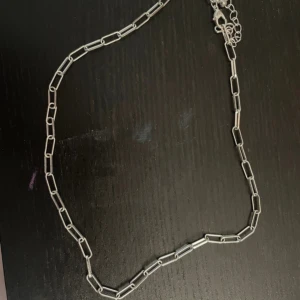 Silverfärgat halsband med rektangulära länkar - Snyggt silverfärgat halsband med rektangulära länkar. Perfekt för att ge en stilren touch till din outfit. Lätt att matcha med andra smycken.