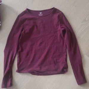 Vinröd långärmad tröja från H&M - En enkel och stilren vinröd långärmad tröja från H&M i ekologisk bomull. Perfekt basplagg med rund halsringning och mjukt material som passar till det mesta. Kom privat för mått eller fler bilder!