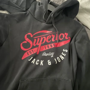 Svart hoodie från Jack & Jones med tryck - Svart hoodie från Jack & Jones. Lite använd men inga stora märkbara märken 