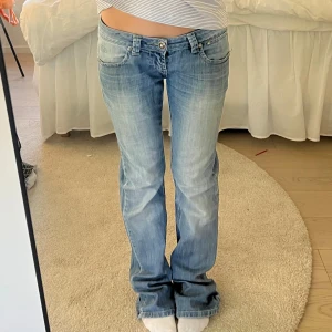 Ljusblå Miss Sixty jeans med bootcut - Säljer ett par ljusblå jeans från Miss Sixty med klassisk femficksdesign och låg midja. Jeansen har bootcut-ben och snygga slitningar framtill för en avslappnad look. Perfekta till vardags med en enkel topp eller hoodie.
