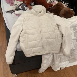 Vit cardigan från zara  - Säljer en snygg vit pufferjacka i nyskick. Jackan har en dragkedja framtill och är långärmad, perfekt för kyliga höst- och vinterdagar. Den är quiltad och har en stilren design som passar till det mesta. Supermysig och varm!