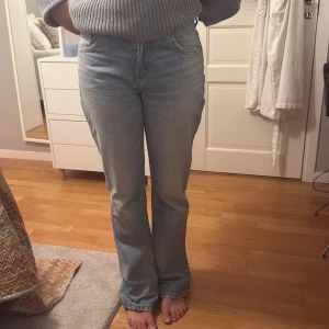 Ljusblå bootcut jeans - Säljer ett par ljusblå jeans med bootcut passform och klassiska fickor både fram och bak. Jeansen har normal passning och är perfekta för en avslappnad stil. Ingen stretch och traditionell jeanslook.