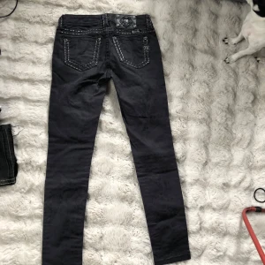Svarta  Miss Me jeans - Säljer ett par svarta jeansbyxor från Miss Me med dekorativa kontrastsömmar och klassisk femficksdesign. 