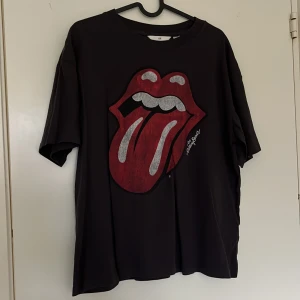 Svart t-shirt med Rolling Stones-tryck från H&M - Svart t-shirt från H&M med stort Rolling Stones-tryck framtill. storlek S ganska stor dock använd 1/2 gånger bara 🩷