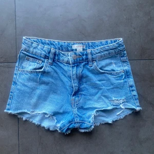  Ljusblå shorts med låg midja och slitningar från Gina Tricot -  Jeans shorts med låg midja och slitningar 