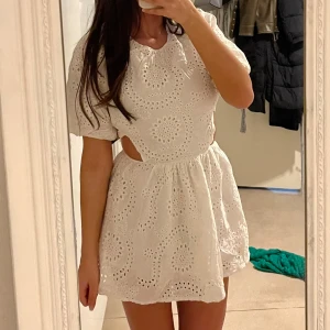 Vit broderad kortklänning med cut-out - Supersöt vit kortklänning med broderade blommönster och puffärmar. Perfekt nu inför student & sommar. Ny utan prislap💓36 men passar även 34! Pris går att diskutera.