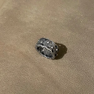 Chrome Colosseum Silver Ring - En kraftfull och stilren ring designad för att ge en rå och rockig edge. Den unika detaljeringen skapar en iögonfallande look, perfekt för den som vill sticka ut. Passar storlek 8.5.