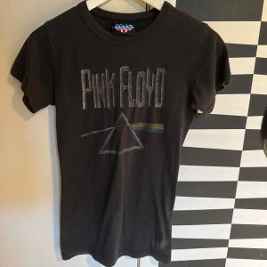 Svart Pink Floyd t-shirt från Junk Food - Cool svart t-shirt med Pink Floyd-tryck på framsidan och 'The Dark Side of the Moon U.S. Tour 1973' på baksidan. Klassisk passform och rund hals. Perfekt för dig som gillar bandtröjor och retrostil. Köpt på en konsert för några år sen