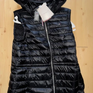 Svart tommy hilfiger väst - Säljer just nu denna feeeta Tommy hilfiger väst. Den är i storlek S helt ny med alla lappar och allt kvar, helt oanvänd. Passar perfekt nu inför våren och sommaren. Självklart äkta! Vid funderingar hör av er!🔥🌟