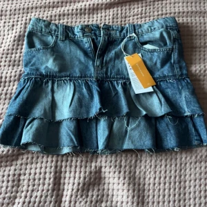 Volang jeans kjol - Säljer en snygg jeans kjol från Gina. Den är helt oanvänd med prislappen kvar. Super snygg till sommaren men inte riktigt för mig💕pris går att diskutera och skrv vid fler frågor eller bilder💕