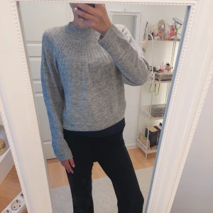 Grå stickad tröja - Mysig grå stickad tröja med rund halsringning och lång ärm. Enkel och stilren design som passar perfekt till vardags. Tröjan har en rak passform och är lätt att matcha med olika outfits. Är I storlek S men passar även M