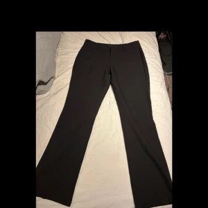 Svarta kostymbyxor från BikBok Vera - Säljer ett par svarta kostymbyxor från BikBok med klassisk passform och raka ben. Byxorna har dragkedja och knapp framtill samt diskreta fickor. Perfekta för en stilren look.