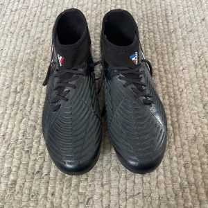 Adidas predator edge1 - Säljer ett par svarta Adidas predator edge1 i storlek 38,2/3. Skorna har mönstrad ovandel och klassiska Adidas-ränder i vitt, blått och rött på sidan. Perfekta för spel på gräsplan. De är bara använda några fåtal gånger. 