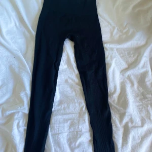 Svarta ribbade leggings från SHEIN - Svarta leggings från SHEIN i ribbat material. Hög midja och tight passform som sitter skönt mot kroppen. Perfekta för både träning och chill. Storlek S (EU 36).