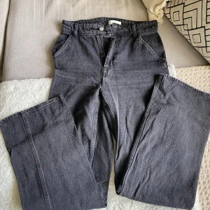 Svarta cargopants i denim - Säljer ett par svarta cargopants i jeansmaterial med raka ben och klassiska cargofickor på sidorna från HM. Byxorna har normal passform och stängs med dragkedja och knapp. Används ca 2 gånger. I storlek 36. 
