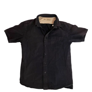 Muji skjorta - Marinblå skjorta med korta ärmar och klassisk krage. Skjortan har knappar framtill och en bröstficka. Tillverkad i 100% bomull vilket gör den skön och luftig. Perfekt för en stilren och enkel look. Storleken är igenkligen M men passar S.