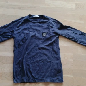 Långärmad tröja från Stone Island 156cm - Säljer en mörkblå långärmad tröja från Stone Island Junior. Tröjan har rund halsringning och den klassiska Stone Island-loggan på bröstet. Perfekt för dig som gillar stilrena och exklusiva plagg.